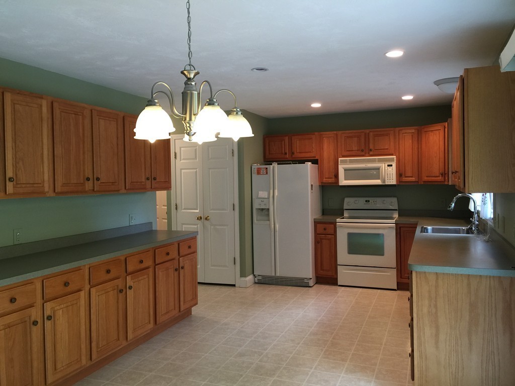 8 Autumn Woods Drive, Unit 8 Rutland, MA 01543 - Photo 5 of 16 a kitchen with stainless steel appliances granite countertop a refrigerator a stove a sink and a microwave