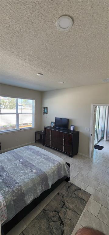 1823 Spring Shower Circle Kissimmee, FL 34744 - Photo 14 of 38 a bedroom with a bed and window