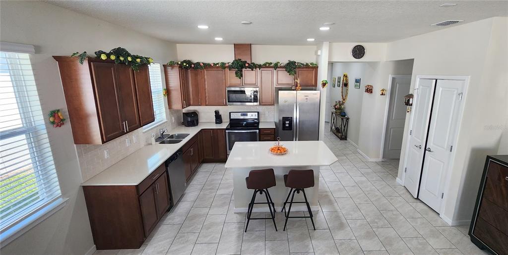 1823 Spring Shower Circle Kissimmee, FL 34744 - Photo 6 of 38 a dining table chair and a refrigerator in a kitchen