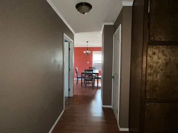 a view of a hallway with dining area and chandelier