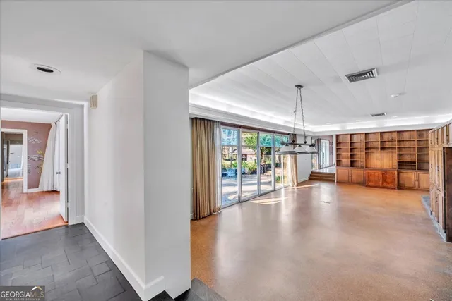 a view of a big room with wooden floor and windows