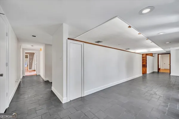 a view of a hallway with wooden floor and windows