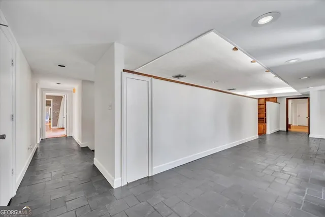 a view of a hallway with wooden floor and windows