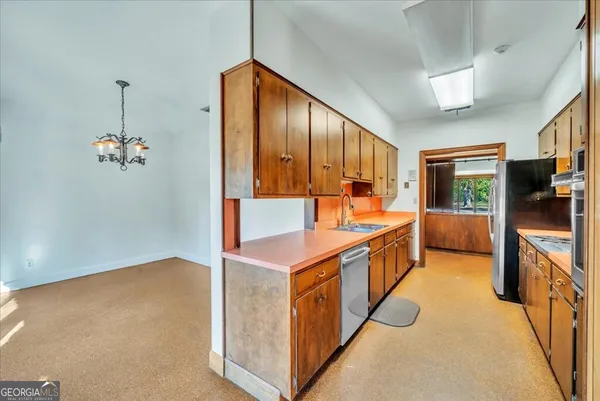 a kitchen with stainless steel appliances granite countertop a stove a sink and a refrigerator