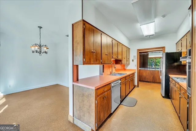 a kitchen with stainless steel appliances granite countertop a stove a sink and a refrigerator