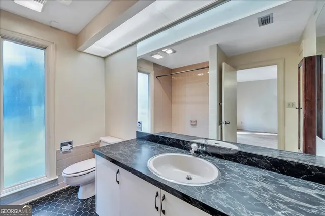 a bathroom with a granite countertop sink and a mirror