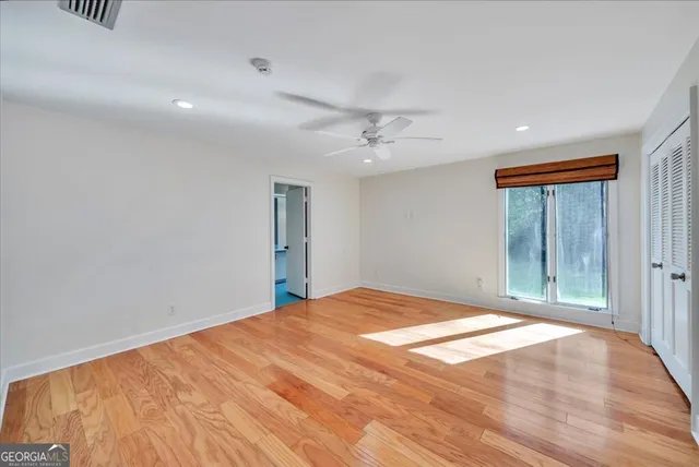 a spacious bedroom with a bed and a flat screen tv