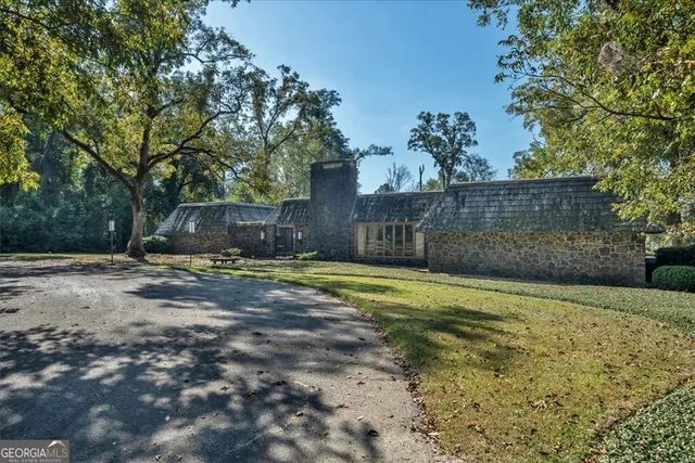 a backyard of a house with plants and large trees