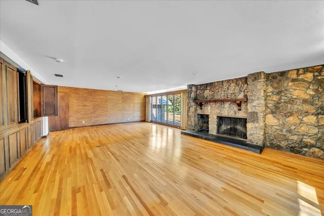a view of empty room with wooden floor and fireplace