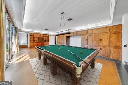 a room with pool table and windows