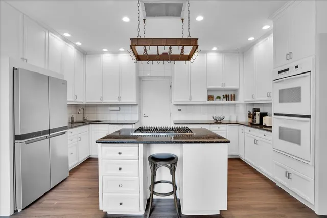 a kitchen with stainless steel appliances granite countertop a stove a sink and a refrigerator