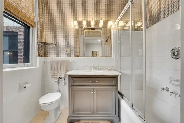 a bathroom with a granite countertop toilet a sink and a mirror