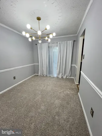 an empty room with stairs and a chandelier fan