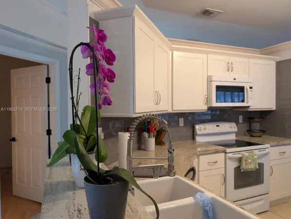a kitchen with a white stove top oven and white cabinets