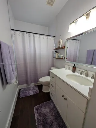 a bathroom with a sink a toilet and shower curtain