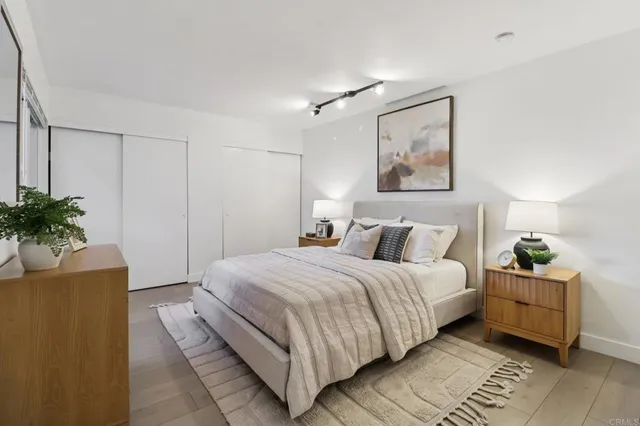 a bedroom with a large bed and a potted plant