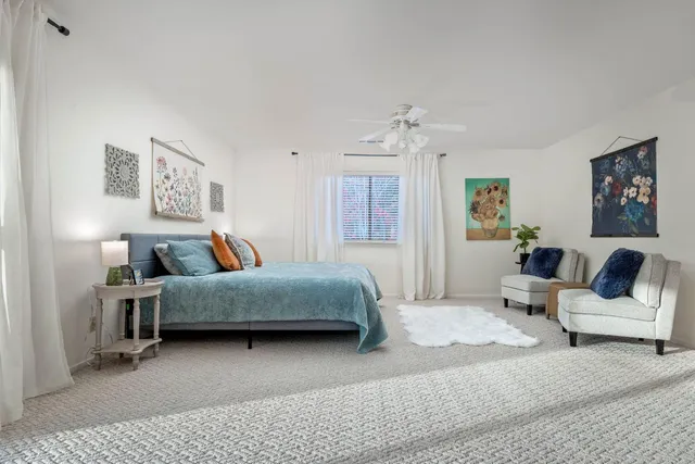 an empty room with windows and ceiling fan