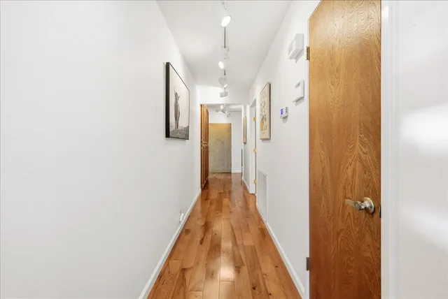 an empty room with chandelier fan and windows