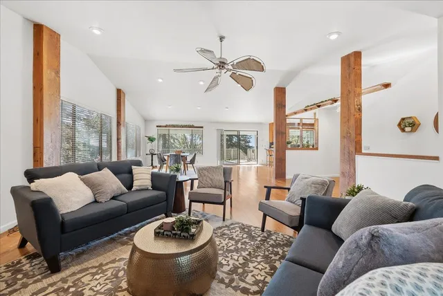 a kitchen with stainless steel appliances granite countertop a stove top oven a sink a dining table and chairs