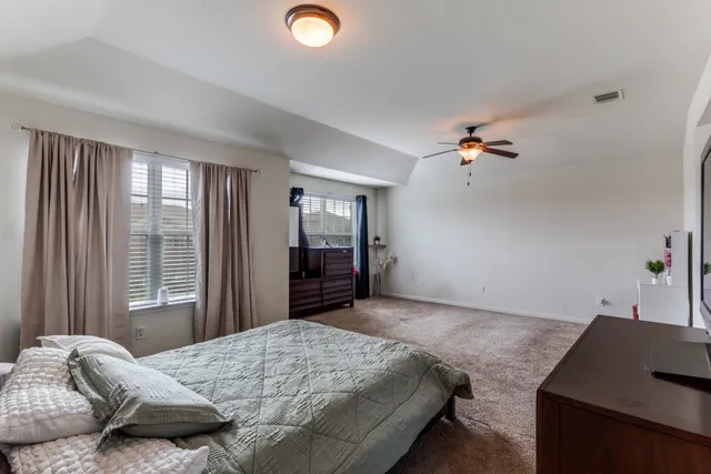 a bedroom with a bed and dresser with mirror