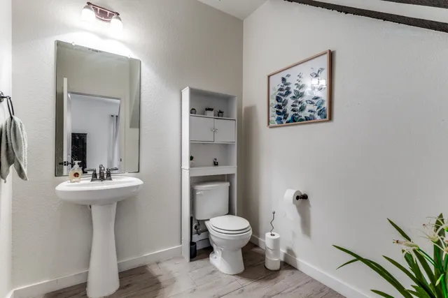 a bathroom with a toilet a sink and mirror