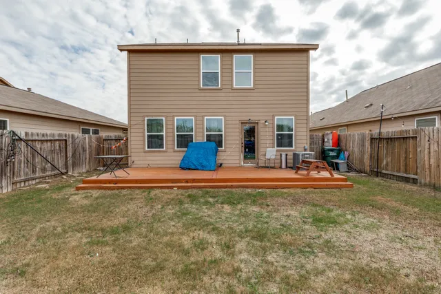 a view of a house with backyard and a tree