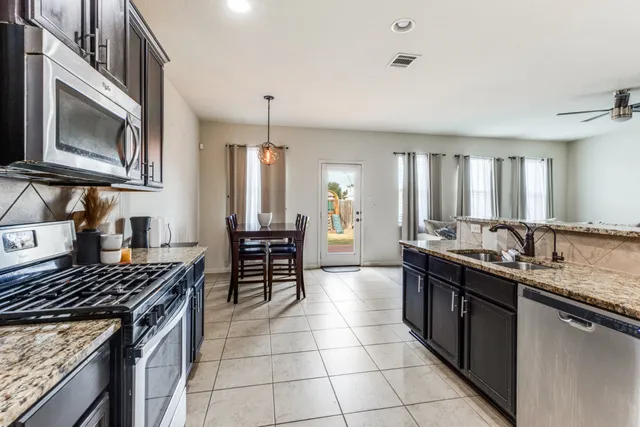 a kitchen with a stove sink cabinets and microwave