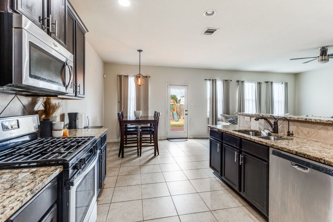 1524 Treeta Trail Kyle, TX 78640 - Photo 10 of 25 a kitchen with a stove sink cabinets and microwave