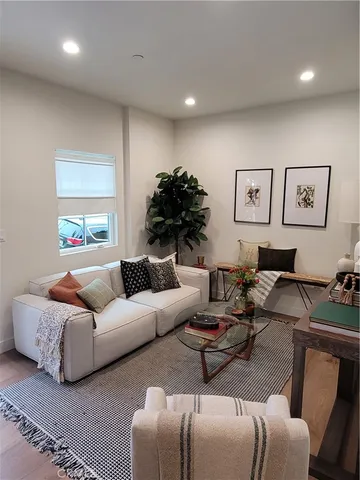 a living room with furniture a table and wooden floor