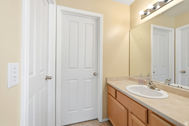 5485 Heather Way Tooele, UT 84074 - Photo 27 of 41 Bathroom vanity featuring a light-toned countertop, undermount sink, and chrome faucet