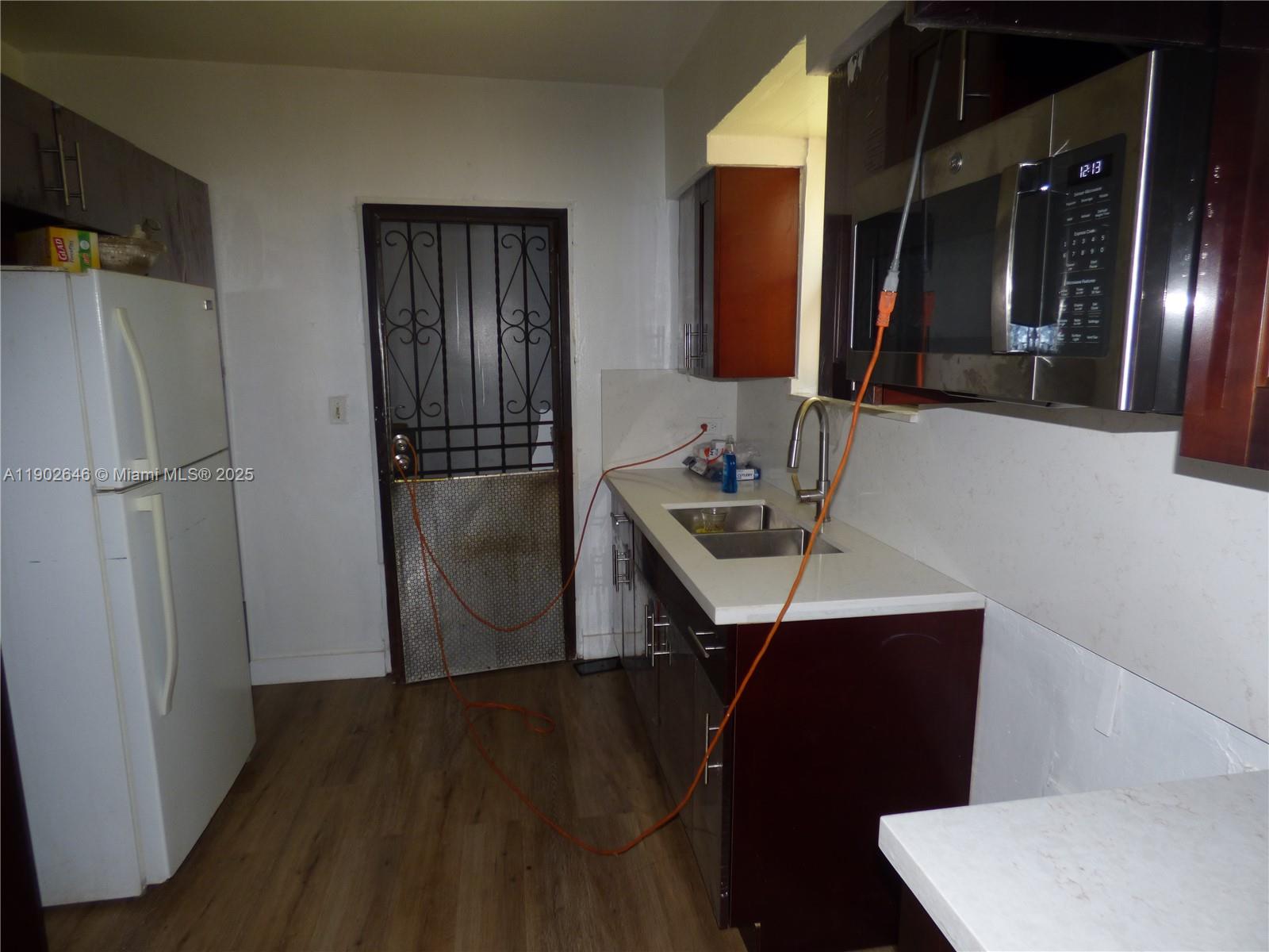 347 Northwest 42nd Street Miami, FL 33127 - Photo 3 of 11 a kitchen with a sink a refrigerator freezer a washer and dryer