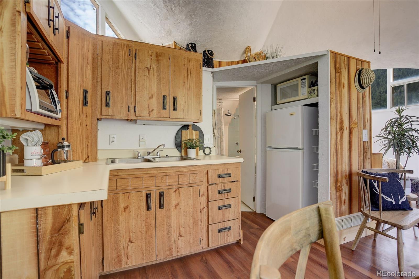 2212 Alvarado Road Georgetown, CO 80444 - Photo 12 of 19 a kitchen with cabinets and wooden floors