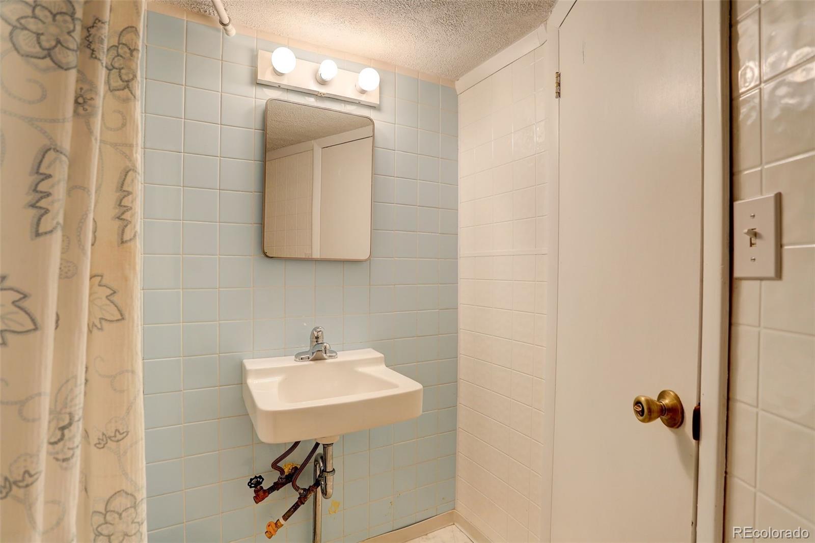 2212 Alvarado Road Georgetown, CO 80444 - Photo 6 of 19 a bathroom with a sink a light fixture and a mirror