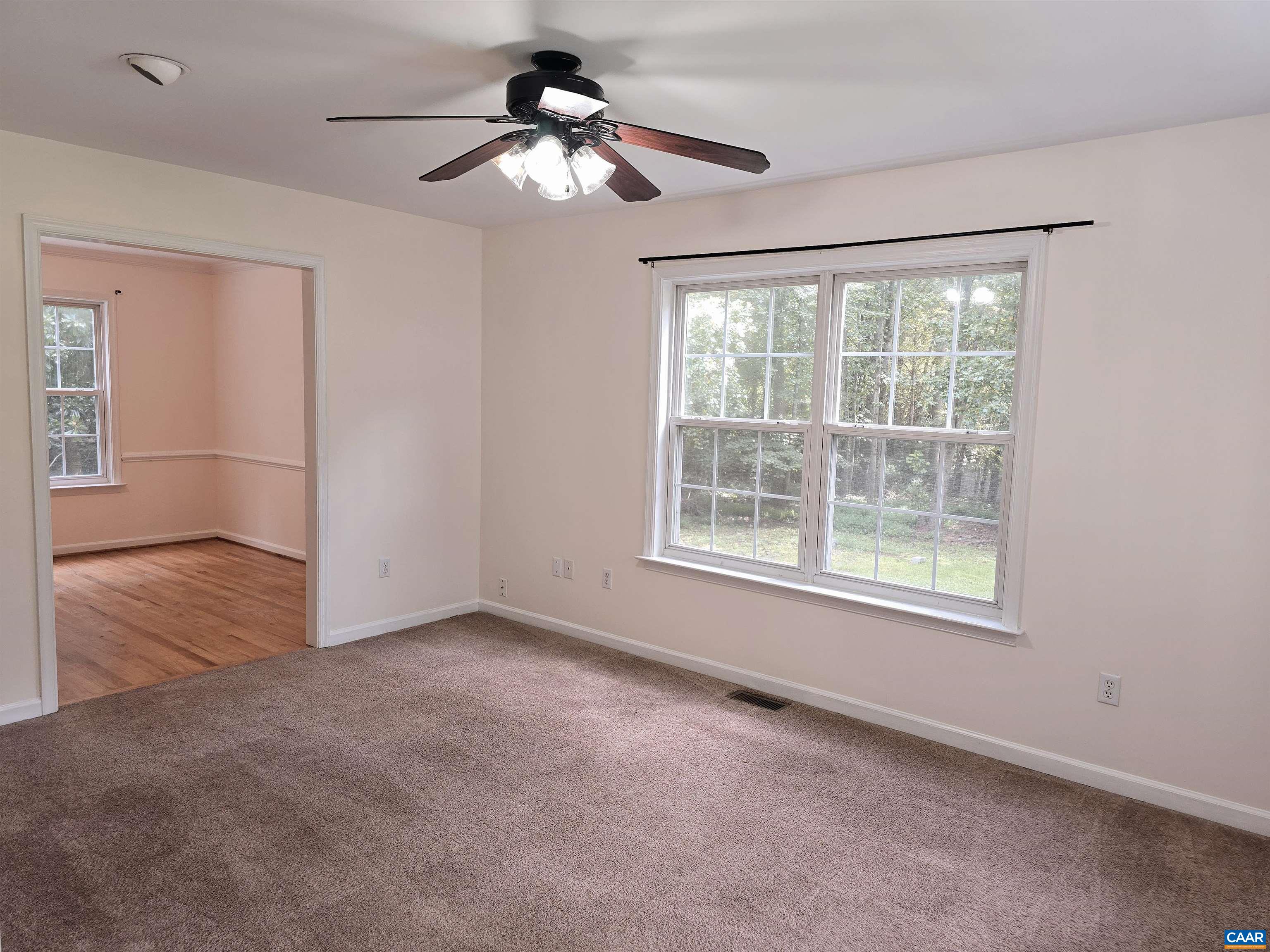 259 Spring Oaks Lane Ruckersville, VA 22968 - Photo 11 of 26 an empty room with chandelier fan and windows