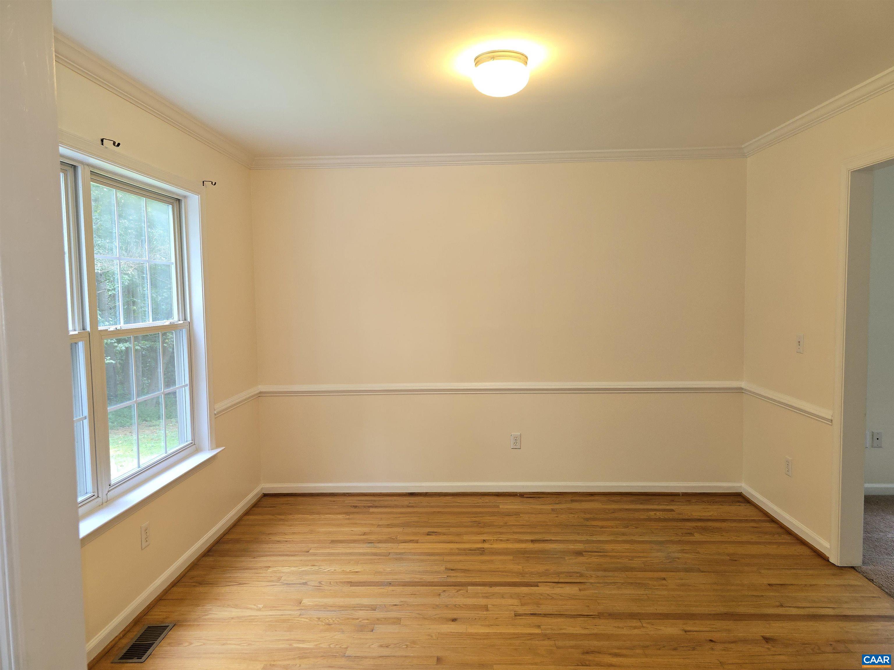 259 Spring Oaks Lane Ruckersville, VA 22968 - Photo 13 of 26 a view of an empty room with wooden floor and a window