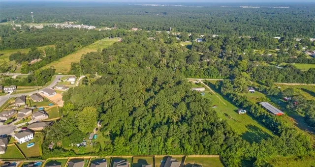 an aerial view of residential houses with outdoor space and trees