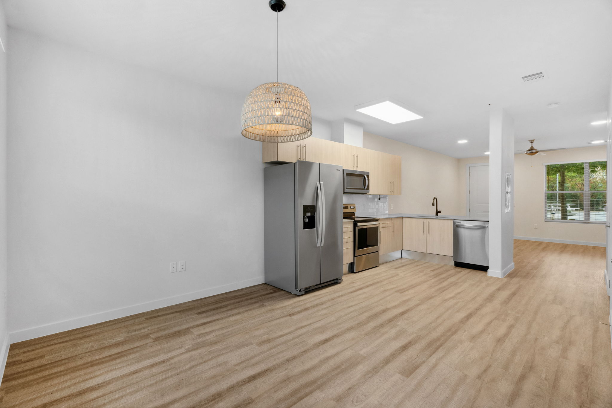 7805 Cooper Lane, Unit 606 Austin, TX 78745 - Photo 3 of 35 a kitchen with stainless steel appliances a refrigerator a sink dishwasher a oven and a dining table with wooden floor