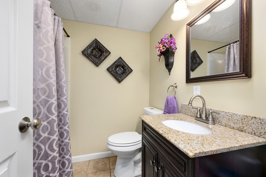 138 Sprague Street Fall River, MA 02724 - Photo 22 of 34 a bathroom with a granite countertop toilet sink and mirror