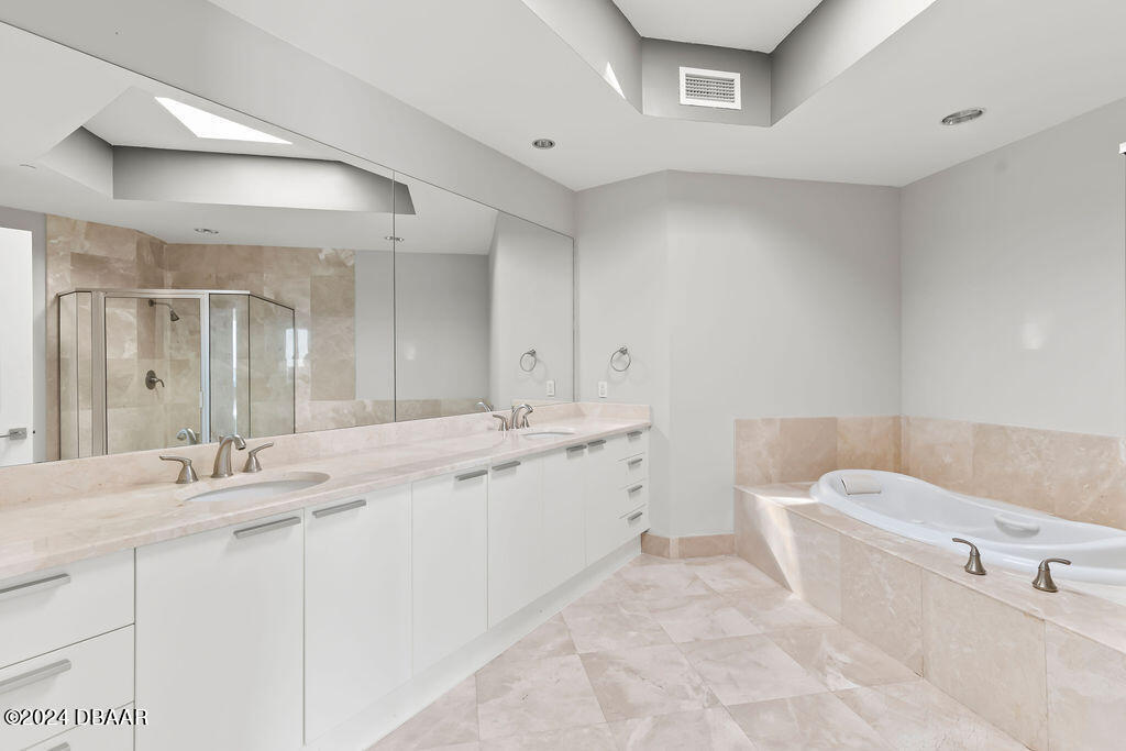 241 Riverside Drive, Unit 2610 Daytona Beach, FL 32117 - Photo 17 of 31 a bathroom with a tub a sink and mirror