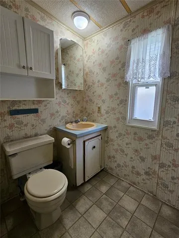 a bathroom with a granite countertop toilet a sink and a shower