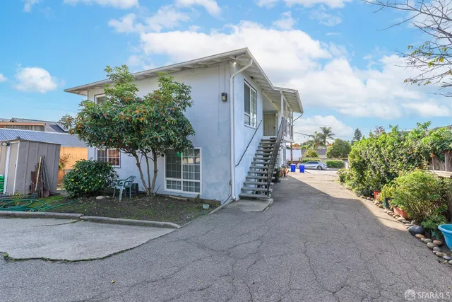 a view of a house with a yard and potted plants