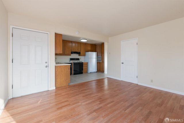 a view of a kitchen with wooden floor and a refrigerator
