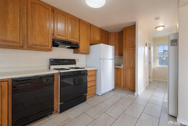 a kitchen with a refrigerator sink and cabinets