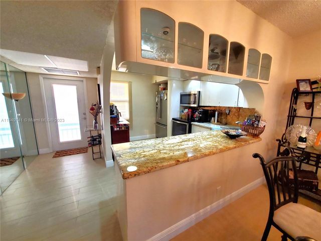 a kitchen with stainless steel appliances granite countertop a sink and a stove