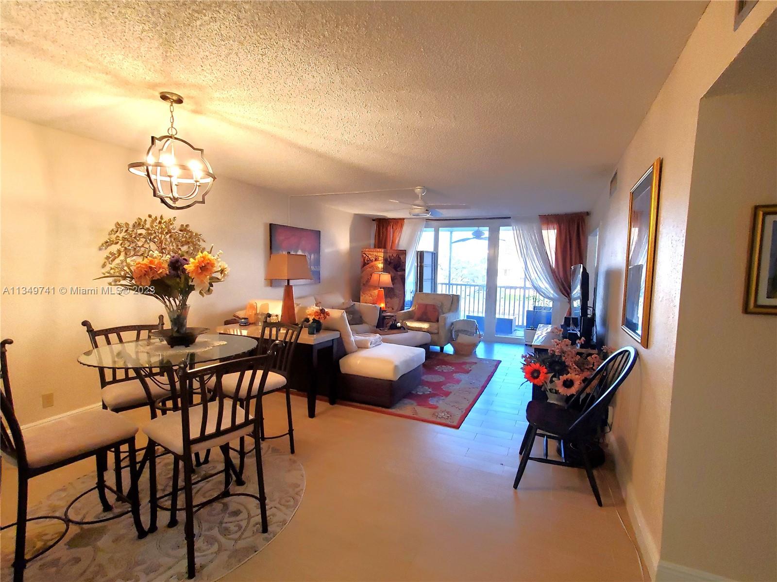 Lighthouse Point Lighthouse Point, FL 33064 - Photo 8 of 52 a living room with furniture a rug and a chandelier