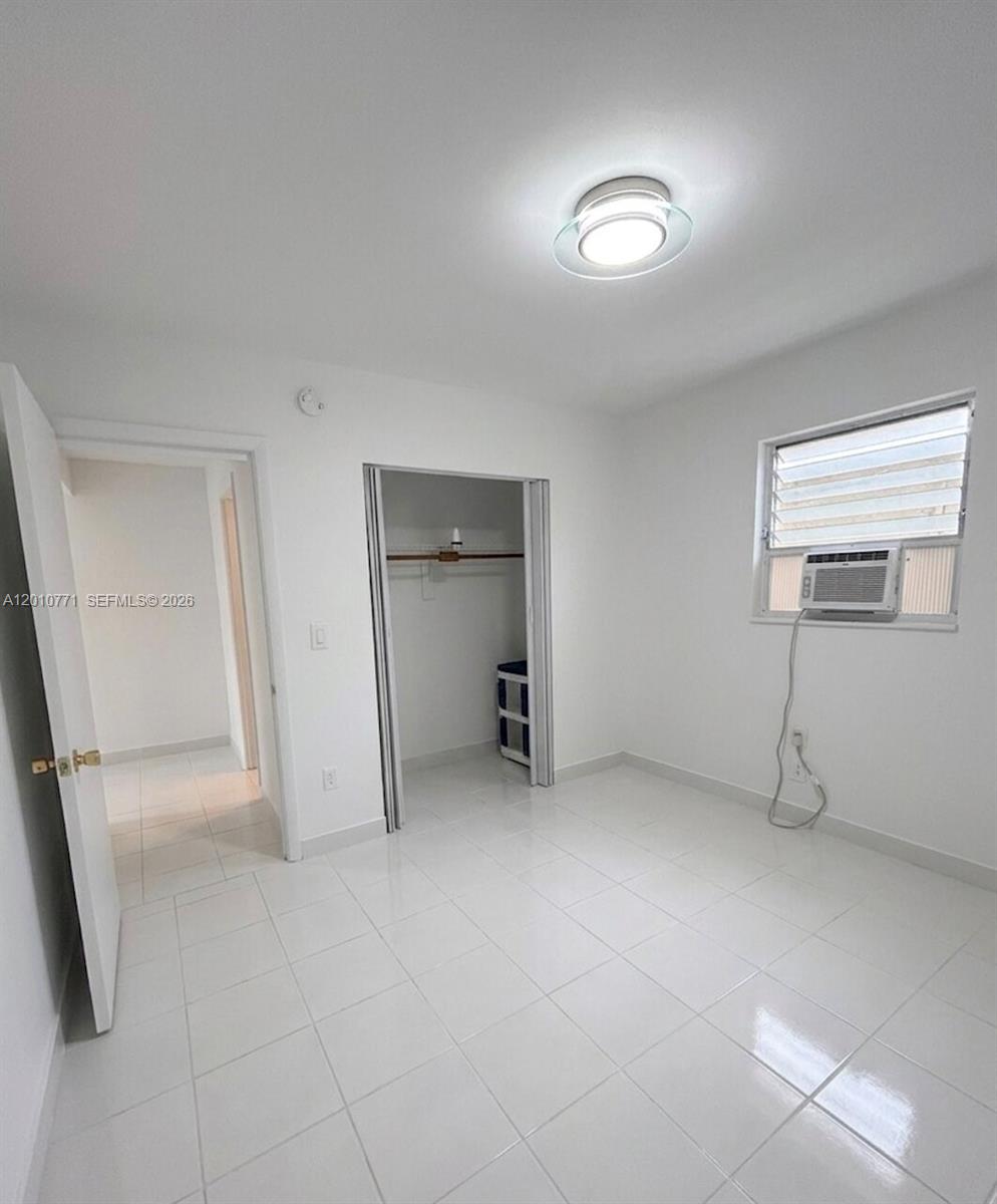 718 Southwest 11th Avenue, Unit 5 Miami, FL 33130 - Photo 3 of 6 an empty room with fireplace and windows
