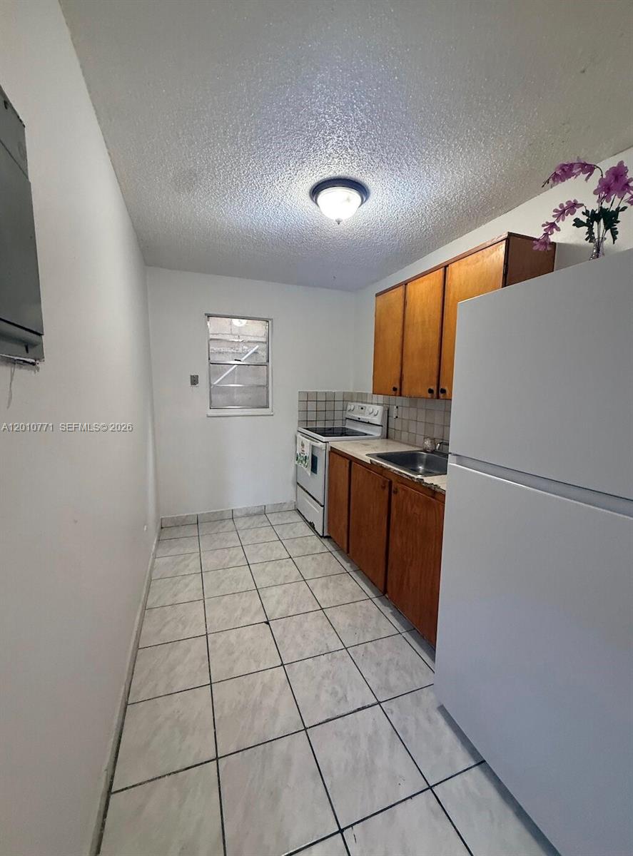 718 Southwest 11th Avenue, Unit 5 Miami, FL 33130 - Photo 5 of 6 a kitchen with stainless steel appliances a refrigerator sink and cabinets