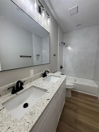 a bathroom with a tub sink and mirror