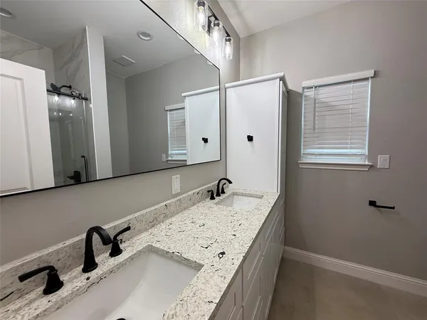a bathroom with a granite countertop sink and a mirror