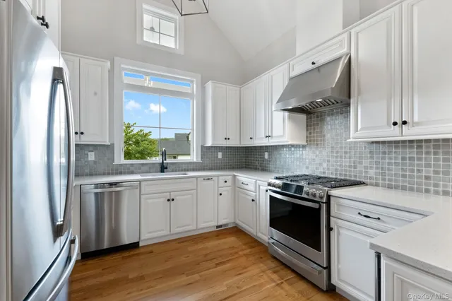 a kitchen with stainless steel appliances granite countertop a stove a sink and a refrigerator